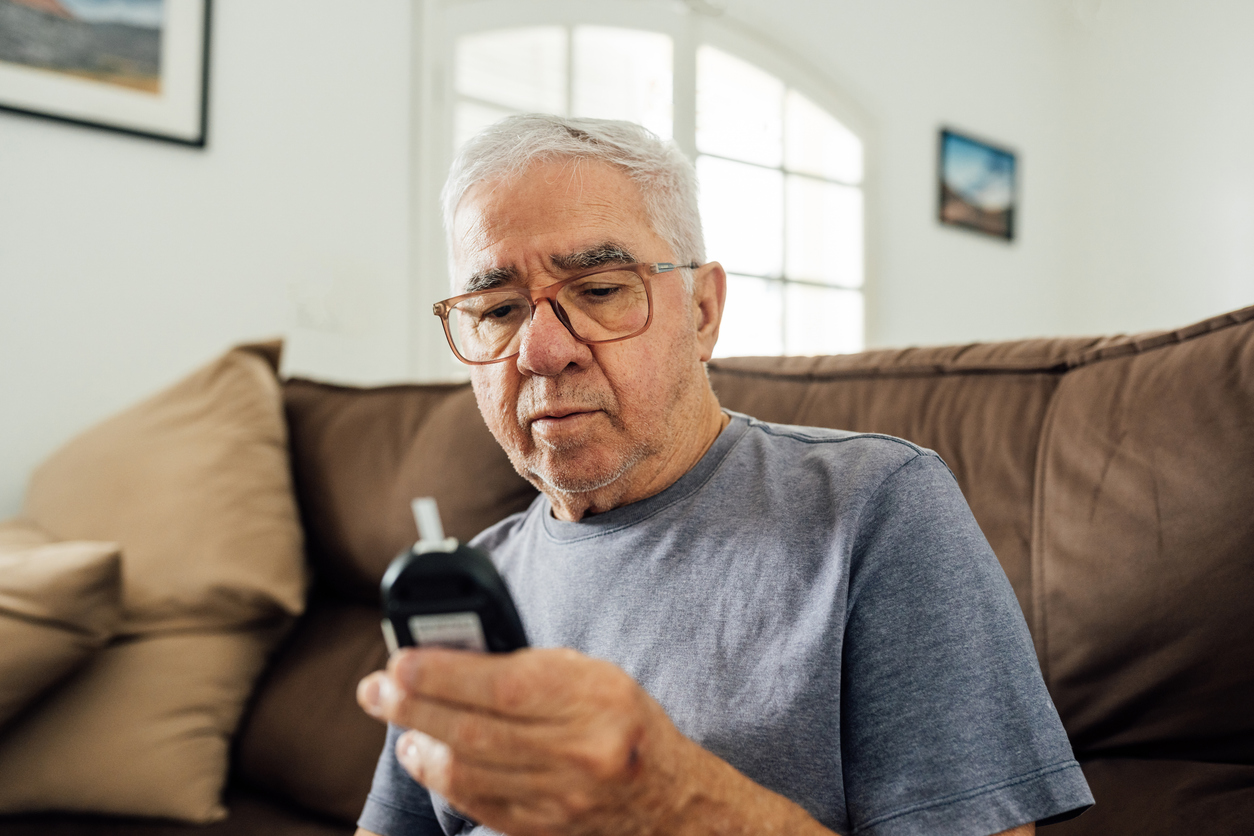 Man looking at glucometer result at home